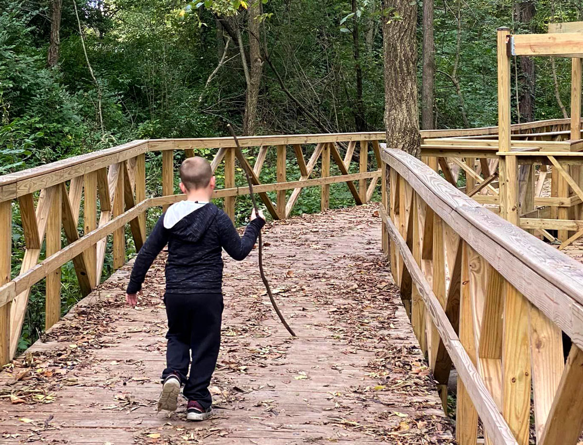 A child hiking on the Historic Forks of the Wabash boardwalk
