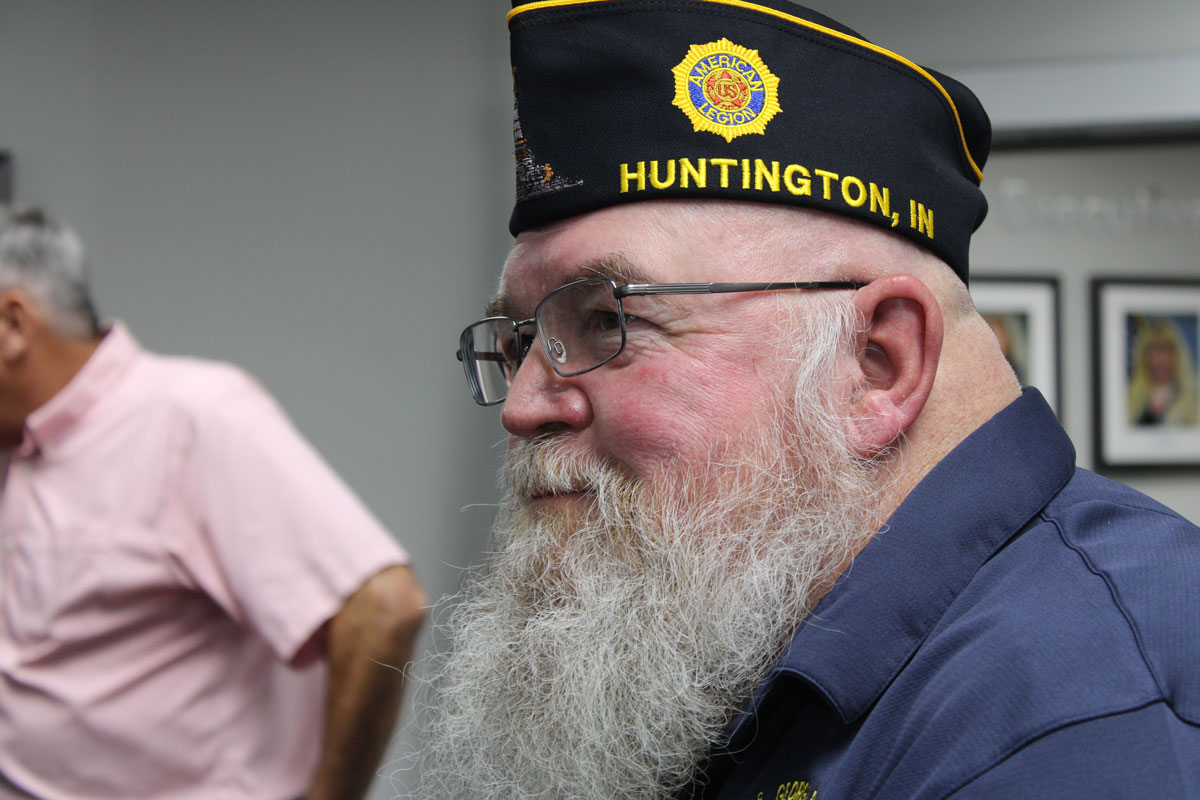 A veteran wearing an American Legion hat standing outdoors