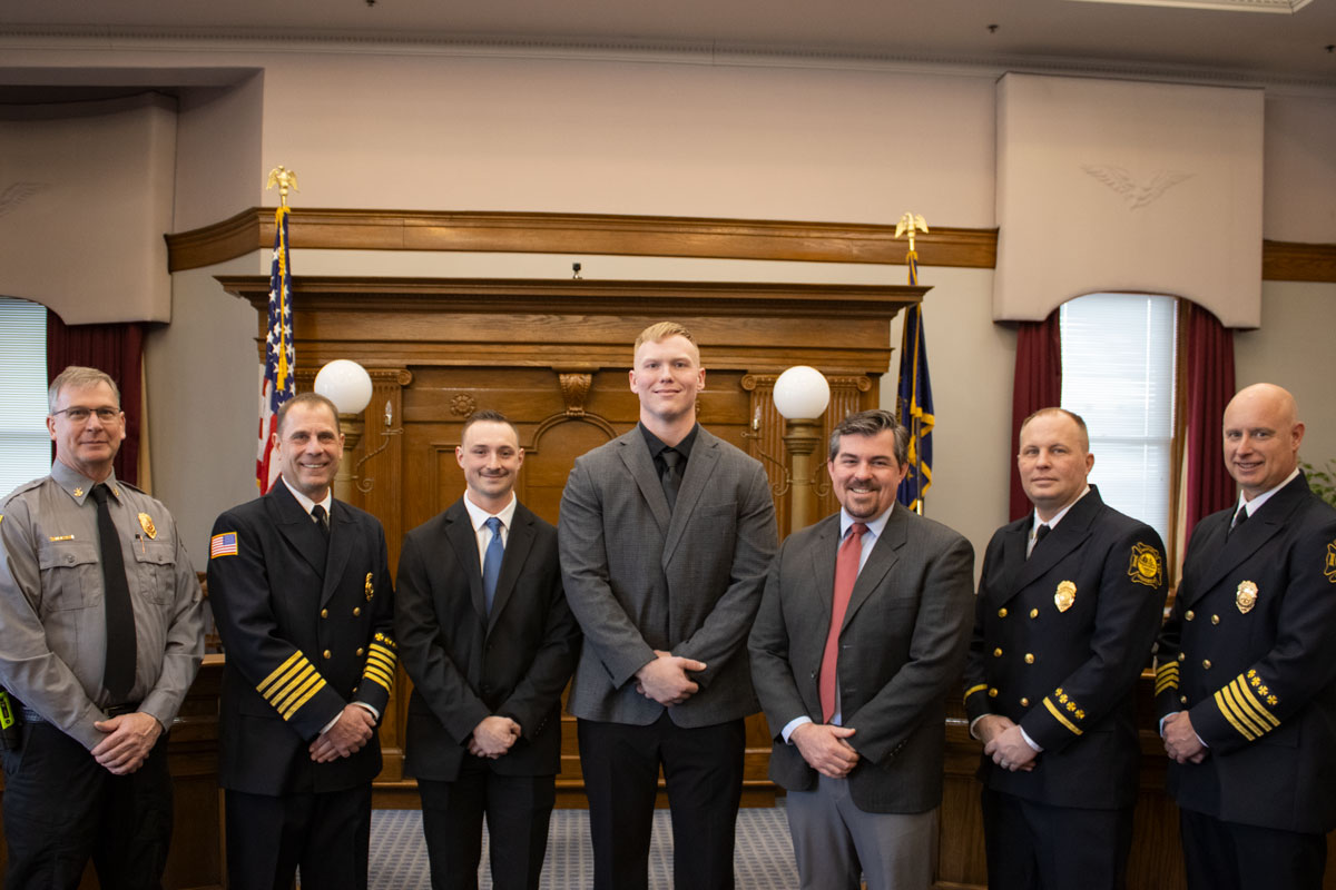 Two recruits pose with the Mayor and Fire Department officials