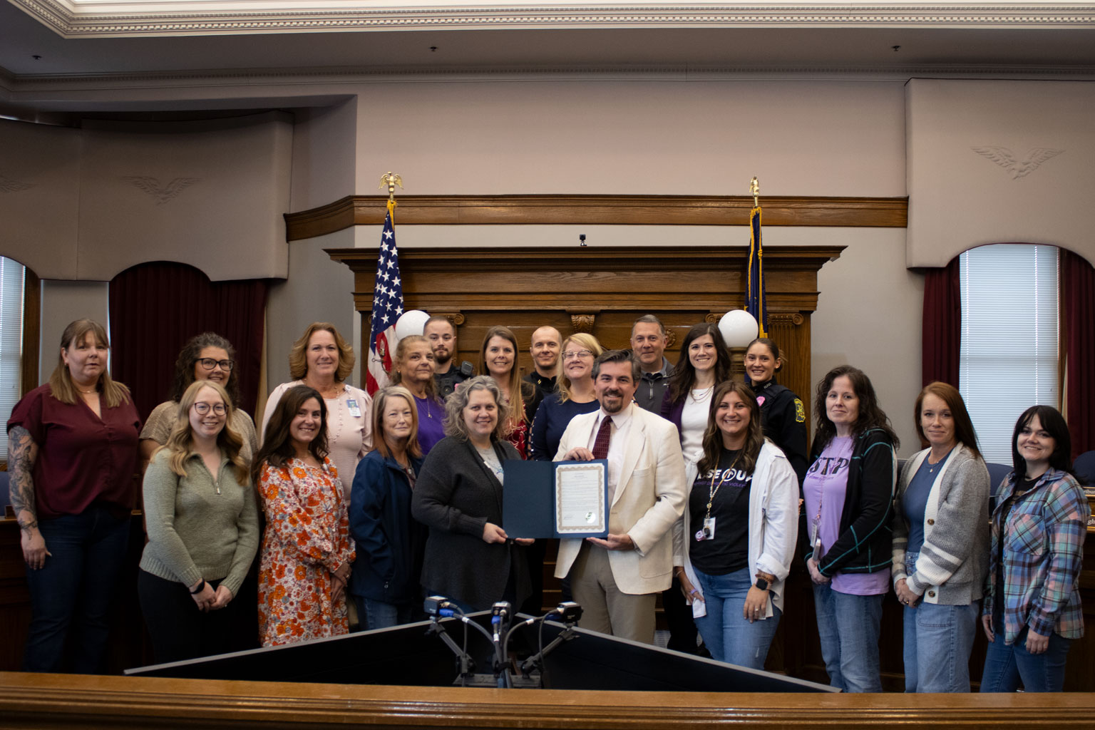 Huntington city officials and community members stand together as the Mayor signs a proclamation declaring October 2025 as Domestic Violence Awareness Month.